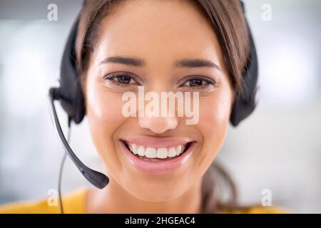 Wie kann ich Ihnen heute helfen? Porträt eines attraktiven jungen Kundendienstmitarbeiters, der ein Headset trägt. Stockfoto