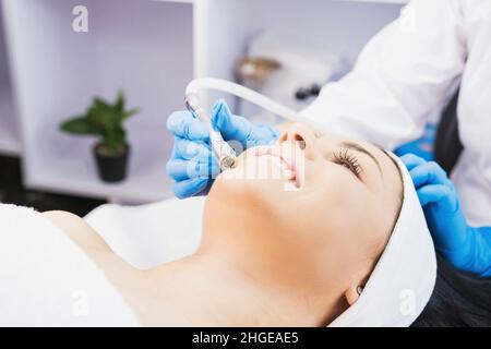 Kosmetologe macht Verfahren Mikrodermabrasion gegen Akne und Mitesser zu einer Frau im Schönheitssalon. Stockfoto