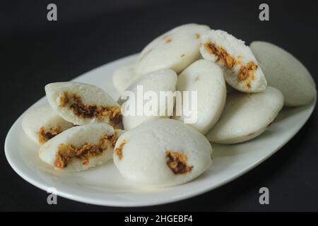 Gefüllter, gedämpfter Reiskuchen mit Hühnchen. Gedämpfter Reiskuchen, gefüllt mit Chicken Masala. Gemeinhin als Huhn gefüllt Idli in Kerala. Serviert mit Kokosnuss Stockfoto