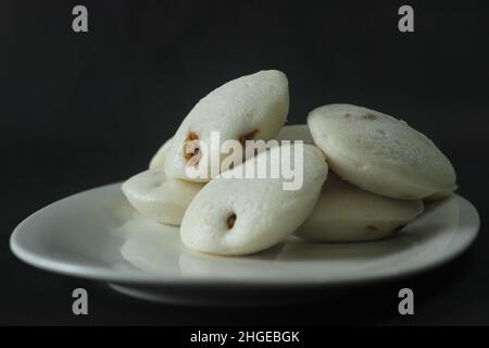 Gefüllter, gedämpfter Reiskuchen mit Hühnchen. Gedämpfter Reiskuchen, gefüllt mit Chicken Masala. Gemeinhin als Huhn gefüllt Idli in Kerala. Serviert mit Kokosnuss Stockfoto