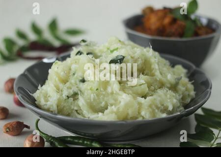 Zerschmetterte Tapioka mit grünen Chilischoten und Schalotten, serviert mit Chicken Gravy. Beliebtes Gericht von Kerala, auch bekannt als Kappa Vevichathu und Kozhi-Kurie. Sh Stockfoto