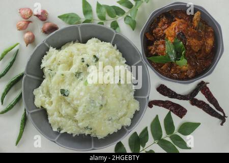 Zerschmetterte Tapioka mit grünen Chilischoten und Schalotten, serviert mit Chicken Gravy. Beliebtes Gericht von Kerala, auch bekannt als Kappa Vevichathu und Kozhi-Kurie. Sh Stockfoto