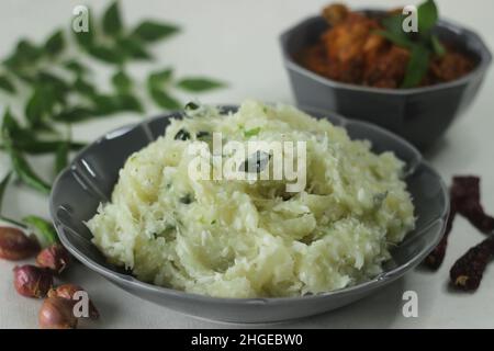 Zerschmetterte Tapioka mit grünen Chilischoten und Schalotten, serviert mit Chicken Gravy. Beliebtes Gericht von Kerala, auch bekannt als Kappa Vevichathu und Kozhi-Kurie. Sh Stockfoto