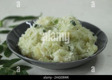 Zermalmter Tapioka mit grünen Chilischoten und Schalotten. Beliebtes Gericht von Kerala gemeinhin als Kappa vevichathu. Aufgenommen auf weißem Hintergrund Stockfoto