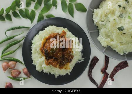 Zerschmetterte Tapioka mit grünen Chilischoten und Schalotten, serviert mit Chicken Gravy. Beliebtes Gericht von Kerala, auch bekannt als Kappa Vevichathu und Kozhi-Kurie. Sh Stockfoto