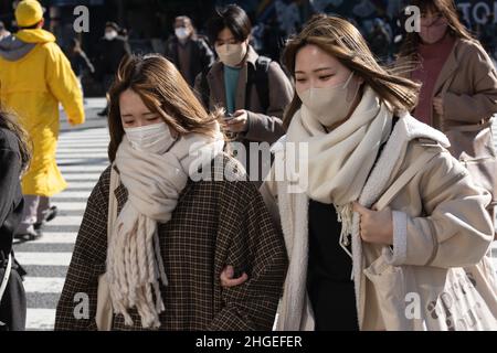 Tokio, Japan. 13th Januar 2022. Frauen mit Gesichtsmasken als Vorsichtsmaßnahme gegen die Ausbreitung von covid-19 gehen über Shibuya Crossing während der Mittagszeit. (Bild: © Stanislav Kogiku/SOPA Images via ZUMA Press Wire) Stockfoto