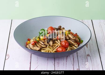 Pasta-Trüffel Aglio Oglio mit Pilzen und Tomaten in einer Schüssel auf Holzboden Stockfoto