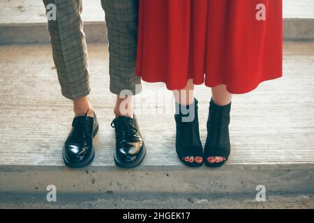 Paare, die auf der Straße bleiben, sind in stilvollem, trendigem Outfit. Das schönste Paar Schuhe. Beine eines jungen Paares in schönen Schuhen. Foto Im Schuhgeschäft Stockfoto