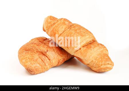 Zwei Croissants isoliert auf weißem Hintergrund. Goldene Farbe Stockfoto