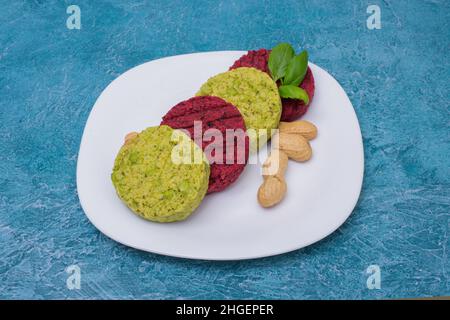 Vegetarische Koteletts mit Kichererbsen, Patty Beete Roots, Bohnen Basilikum und Erdnüssen auf einem Teller. Gesundes Essen für Veganer, gesundes Essen, Menü. Restaurantgericht i Stockfoto