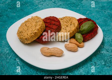 Vegetarische Koteletts mit Kichererbsen, Patty Beetroots, Basilikum und Erdnüssen auf einem Teller. Gesundes Essen für Veganer, gesundes Essen, Menü. Restaurant Gericht in Essen Stockfoto