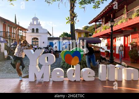 Medellin, Antioquia, Kolumbien - 7 2021. Dezember: Zwei Frauen posieren auf dem Schild „Ich liebe Medellin“ in einem Park, der das Department of Antioquia vertritt Stockfoto