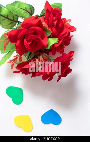 Rote Rosen und kleine Herzen auf weißem Hintergrund Stockfoto