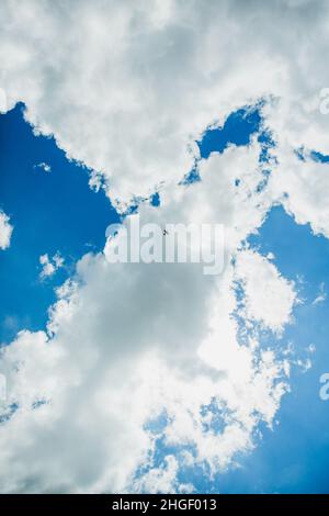 Ein einziges Sportflugzeug am blauen Himmel mit Wolken. Kunstflug-Manöver im Flugzeug, Stunt. Budapest, Ungarn. Ansicht von unten Stockfoto