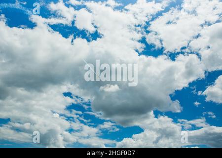 Ein einziges Sportflugzeug mit Aerobatic-Team-Dampfloipen am blauen Himmel. Flache weiße Dampfspuren verfolgen den Hintergrund. Kunstflug-Manöver im Flugzeug, Stunt. Budap Stockfoto