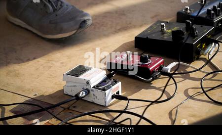 Nahaufnahme Des Mannes, Der Eine Verstärkte Akustische Gitarre Spielt. Clip. Nahaufnahme der Hand spielenden Gitarre. Musiker spielen auf der Bassgitarre. Stockfoto