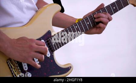 Nahaufnahme Des Mannes, Der Eine Verstärkte Akustische Gitarre Spielt. Clip. Nahaufnahme der Hand spielenden Gitarre. Musiker spielen auf der Bassgitarre. Stockfoto