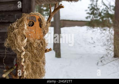 Meteņi Mumming Maske mit Bart, aus Heu, Holzfetzen und Rinde, Aufenthalt im verschneiten Hof Stockfoto