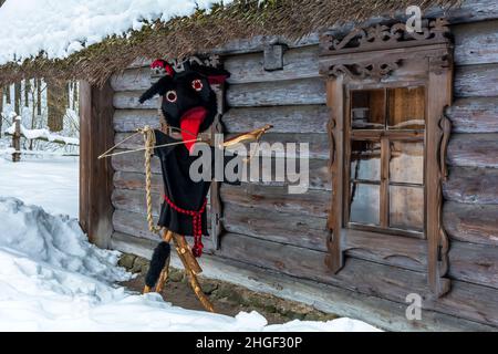 Puppe in Meteņi Mumming Maske und Kostüm des schwarzen Teufels, mit einer Geige und mit seiner roten Zunge heraus Stockfoto