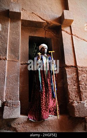 Orthodoxer Priester vor der Tür der Felsenkirche Bet Abba Libanos, Lalibela, Region Amhara, Äthiopien Stockfoto