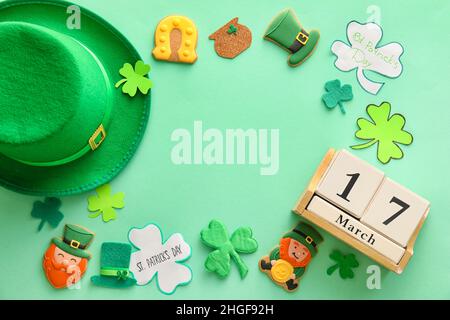 Rahmen aus leckeren Lebkuchengebäck für St. Patrick's Day Feier auf farbigem Hintergrund Stockfoto