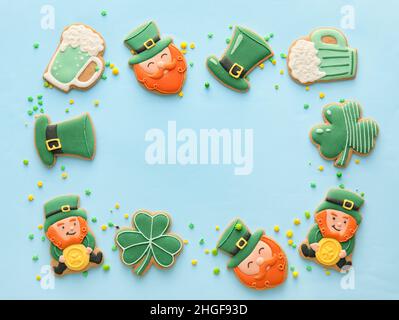 Rahmen aus leckeren Lebkuchengebäck für die St. Patrick's Day Feier auf blauem Hintergrund Stockfoto