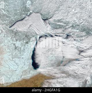 Erdatmosphäre. 10th Januar 2022. In Nordamerika weht oft kalter Wind aus der Arktis oder dem kanadischen Landesinneren in der Wintermitte. Die Winde können nicht nur das verschneite Wetter aufheitern und die Großen Seen einfrieren, sondern auch Merkmale schaffen, die wie lange weiße Autobahnen über den Himmel aussehen. Wolkenstraßen sind parallele Bänder von Kumuluswolken, die sich bilden, wenn frigide Luft nahe der Oberfläche über wärmeres Wasser weht, während eine wärmere Luftschicht (eine Temperaturinversion) über beiden liegt. Das vergleichsweise warme Wasser gibt Wärme und Feuchtigkeit an die kalte Luft ab und leitet die Säulen des HE Stockfoto