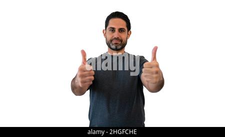 Kaukasischer Mann, der den Daumen hochzeigt und auf weißem Hintergrund steht. Porträt einer Person, die die Kamera anschaut. Schönes männliches Modell. Stockfoto