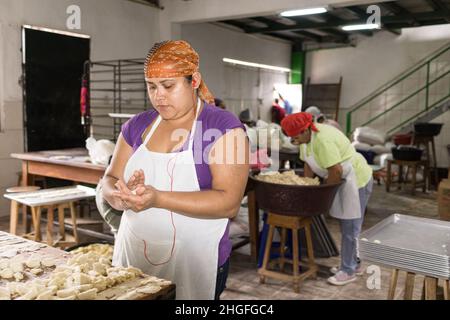 Frauen, die in einer kleinen Fabrik, Rosquillas el Arbolito, in Jinotega, Nicaragua, Rosquillas, ein Gebäck auf maismasa-Basis, herstellen. Stockfoto