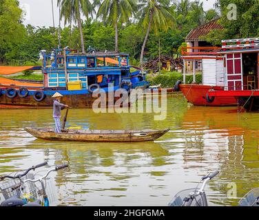 Eine vietnamesische Dame rudert ihr Holzboot den Thu Bon Fluss in der Altstadt von Hoi an, VN. Stockfoto