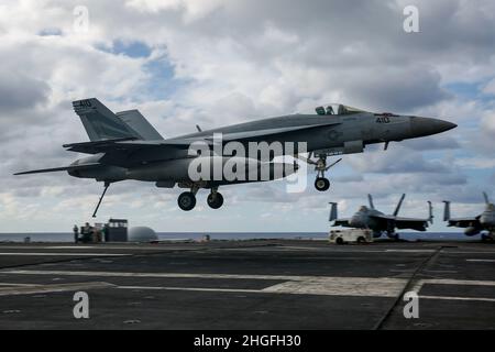 PHILIPPINISCHES MEER (Jan 19, 2022) eine F/A-18E Super Hornet, die den „Vigilanten“ des Strike Fighter Squadron (VFA) 151 zugewiesen wurde, bereitet sich auf eine verhaftete Landung auf dem Flugdeck der USS Abraham Lincoln (CVN 72) vor. Abraham Lincoln, der als Teil der US-Pazifikflotte tätig ist, führt Schulungen durch, um eine freie und offene Region im Indo-Pazifik-Raum zu erhalten und zu schützen. (USA Navy Foto von Mass Communication Specialist 3rd Klasse Michael Singley) Stockfoto