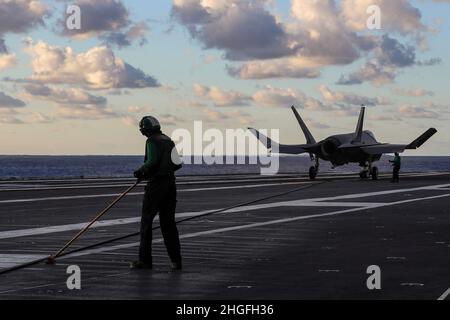 PAZIFISCHER OZEAN (Jan 18, 2022) der Flugzeugflieger von Aviation Boatswain, Tommy Wildman, aus Santa Clarita, Kalifornien, schiebt einen feststehenden Draht auf das Flugdeck der USS Abraham Lincoln (CVN 72) zurück. Abraham Lincoln, der als Teil der US-Pazifikflotte tätig ist, führt Schulungen durch, um eine freie und offene Region im Indo-Pazifik-Raum zu erhalten und zu schützen. (USA Navy Foto von Mass Communication Specialist 3rd Class Javier Reyes) Stockfoto