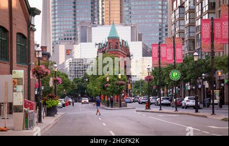 TORONTO, KANADA - 07 21 2020: Sommerabend Blick entlang Front Street mit bunten Blumenbeeten, grünen Bäumen und Gooderham flatiron Gebäude befeuern Stockfoto