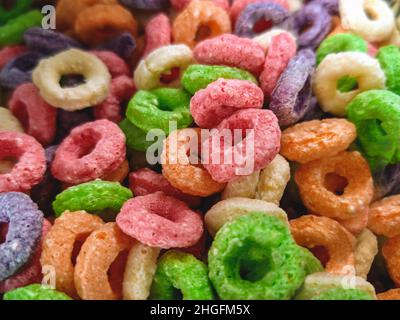 Bunte Früchte zuckerhaltige Maiskornringe. Detailreiche Nahaufnahme dieses nahrhaften und köstlichen Frühstücks- und Snackliebling. Stockfoto