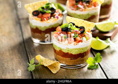 Sieben Schichten Dip in einzelne Tassen, mexikanische Vorspeise Stockfoto