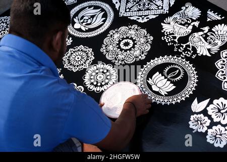 Indischer Verkäufer Mann Herstellung Rangoli aus Design-Muster von Rangoli mit Kreisen. Diese schönen Designs werden in jedem hindu-Haus hergestellt, um sie zu dekorieren und zu schmücken Stockfoto