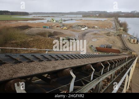 Weeze, Deutschland. 20th Januar 2022. Ein Förderband transportiert Sand am Baggersee der Weeze Kies GmbH & Co.KG der Hülskens Holding. Quelle: Oliver Berg/dpa/Alamy Live News Stockfoto