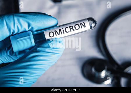 Arzt hält medizinische Röhre mit Probe des neuen Stammes der Coronavirus-Mutationen omicron. Neue covid-19 Variante omicron. Stockfoto