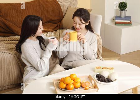 asiatisch-koreanische Frauen verbringen glücklich chitchat und Tee Zeit drinnen Stockfoto