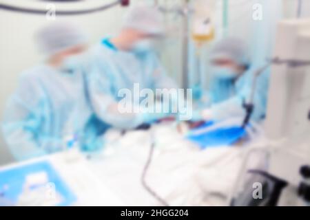 Das Gesundheitspersonal arbeitet in der Notaufnahme mit einem Patienten, der bei einem Unfall verletzt wurde, und hat einen unfokussierten Hintergrund. Stockfoto