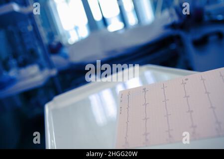 EKG-Diagramm auf dem Schreibtisch im Zimmer des Patienten in der Nacht. Stockfoto