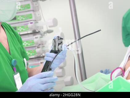 Ein Arzt hält die endoskopische Sonde in Handschuhen, um mit dem diagnostischen Verfahren für den Patienten zu beginnen. Stockfoto