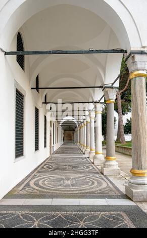 Draußen, historische weiße Reihen von Bögen und Säulen. Historischer weißer Bogen und Säulen im Schlossgarten. Stockfoto