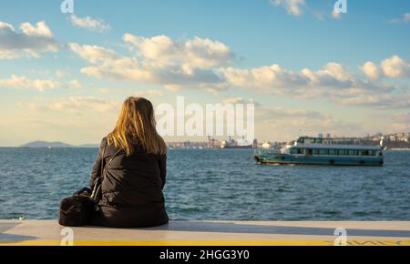 Frau, die am Meer sitzt. Die Frau, die Selbstmord begehen will, sitzt am Meer. Die Frau, die Selbstmord begehen will, sitzt am Meer. Stockfoto