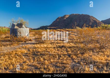 Eingestürzter Windpumpenmast, Wasserbehälter am Hazen Well, ehemalige Ranch in Margies Cove, Sheep Mtn, Maricopa Mtns, Sonoran Desert National Monument, Arizona Stockfoto