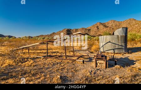 Eingestürzter Windpumpenmast, Wasserbehälter am Hazen Well, ehemalige Ranch in Margies Cove, Maricopa Mountains, Sonoran Desert National Monument, Arizona Stockfoto