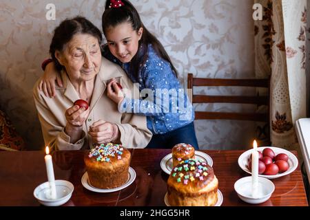 Ältere Frau mit ostereiern und Osterkuchen Stockfoto