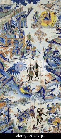 China / Afrika: Kachel tableau zeigt mehrere chinesische Kaufleute und Adlige, die sich zu Hause in einem afrikanischen Dorf, c. 1700. Eine fast ausschließlich traditionelle chinesische Szene dreht sich um zwei robuste afrikanische Dorfbewohner, die in Röcken und Kopfbedeckungen gekleidet sind und Speere halten. Die Afrikaner scheinen amüsiert zu sein, wahrscheinlich neugierig auf den Anblick so vieler reich gekleideter chinesischer Männer und Frauen, Pagoden, Pavillons, chinesischer Laternen, einer Bambusbrücke, Eine chinesische Gondel und sogar ein schwebender Buddha am Himmel. In der unteren Hälfte des Gemäldes tanzt eine afrikanische Frau. Stockfoto