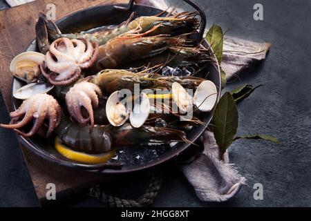 Rohe Garnelen auf dunklem Hintergrund. Mediterranes Diät-Konzept. Stockfoto