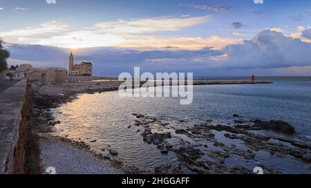 Stadtbild bei Sonnenuntergang von Trani in Apulien, Italien. Im Hintergrund die Kathedrale, die dem Heiligen Nikolaus dem Pilger über dem Hafen gewidmet ist. Stockfoto